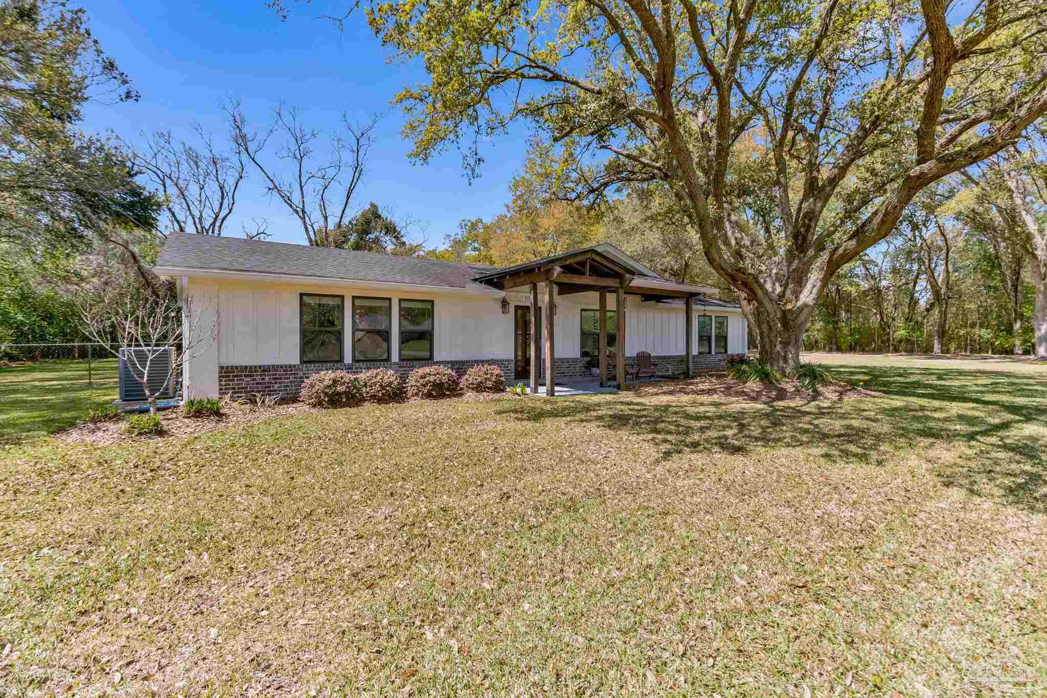 7175 Wallace Drive Pace, FL 32571 - Photo 3 of 71 a front view of a house with a garden