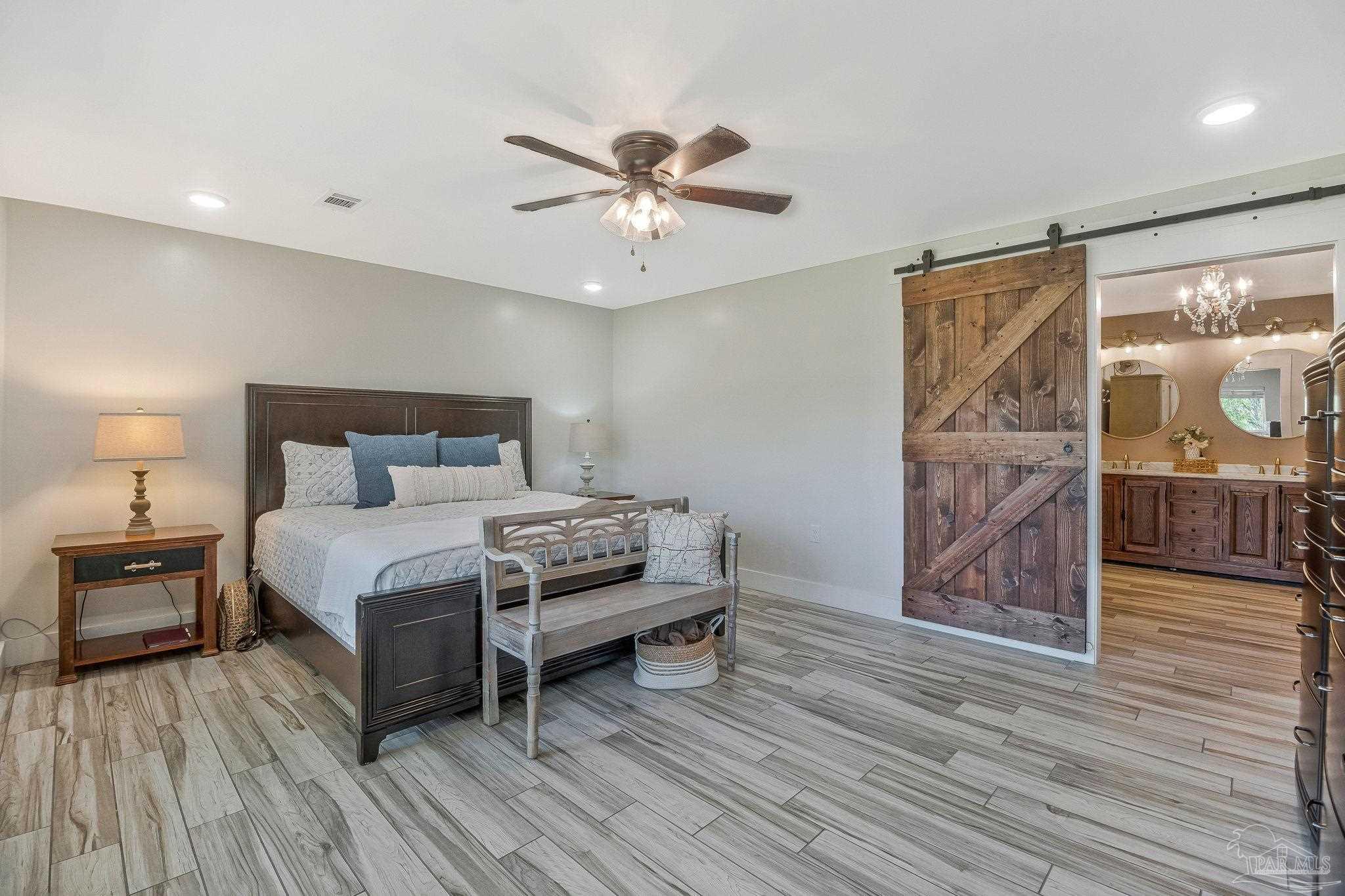 7175 Wallace Drive Pace, FL 32571 - Photo 38 of 71 a bedroom with a bed and wooden floor