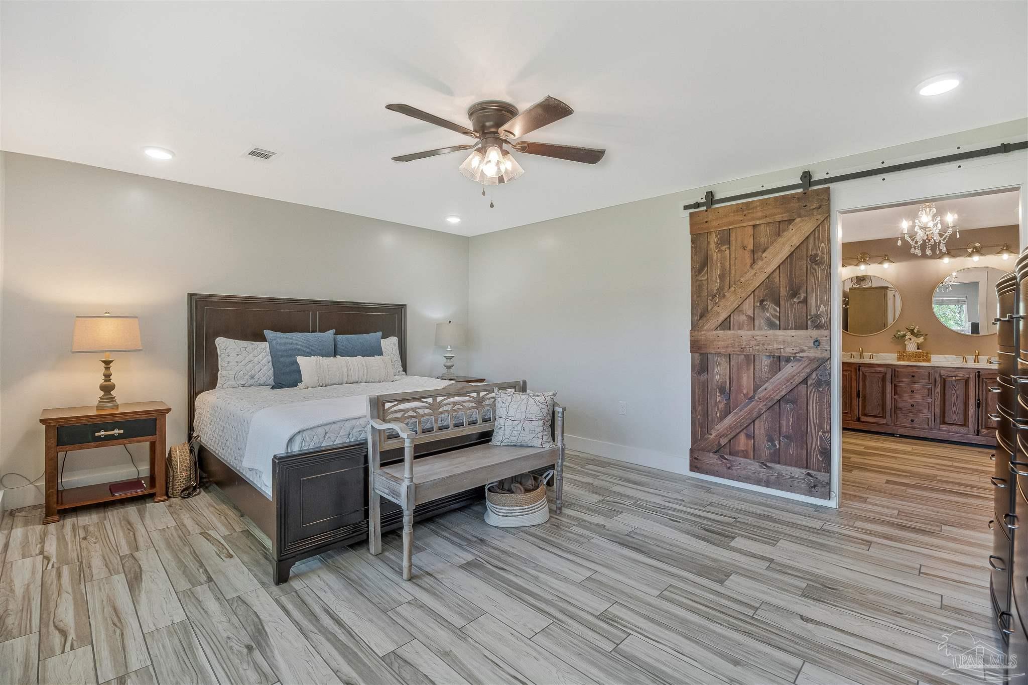 7175 Wallace Drive Pace, FL 32571 - Photo 39 of 71 a bedroom with a bed and wooden floor