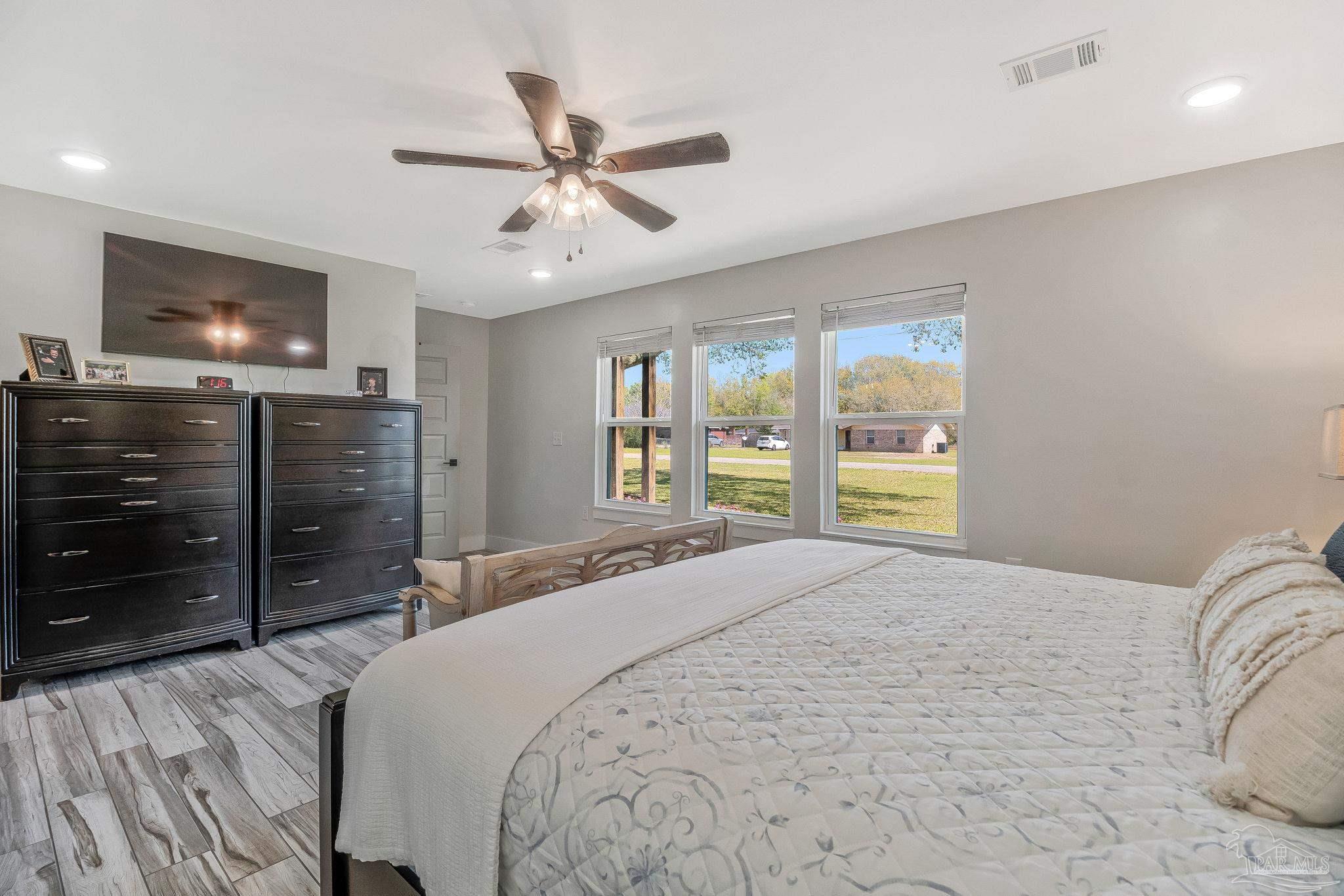 7175 Wallace Drive Pace, FL 32571 - Photo 40 of 71 a bedroom with a bed and a flat tv screen on dresser