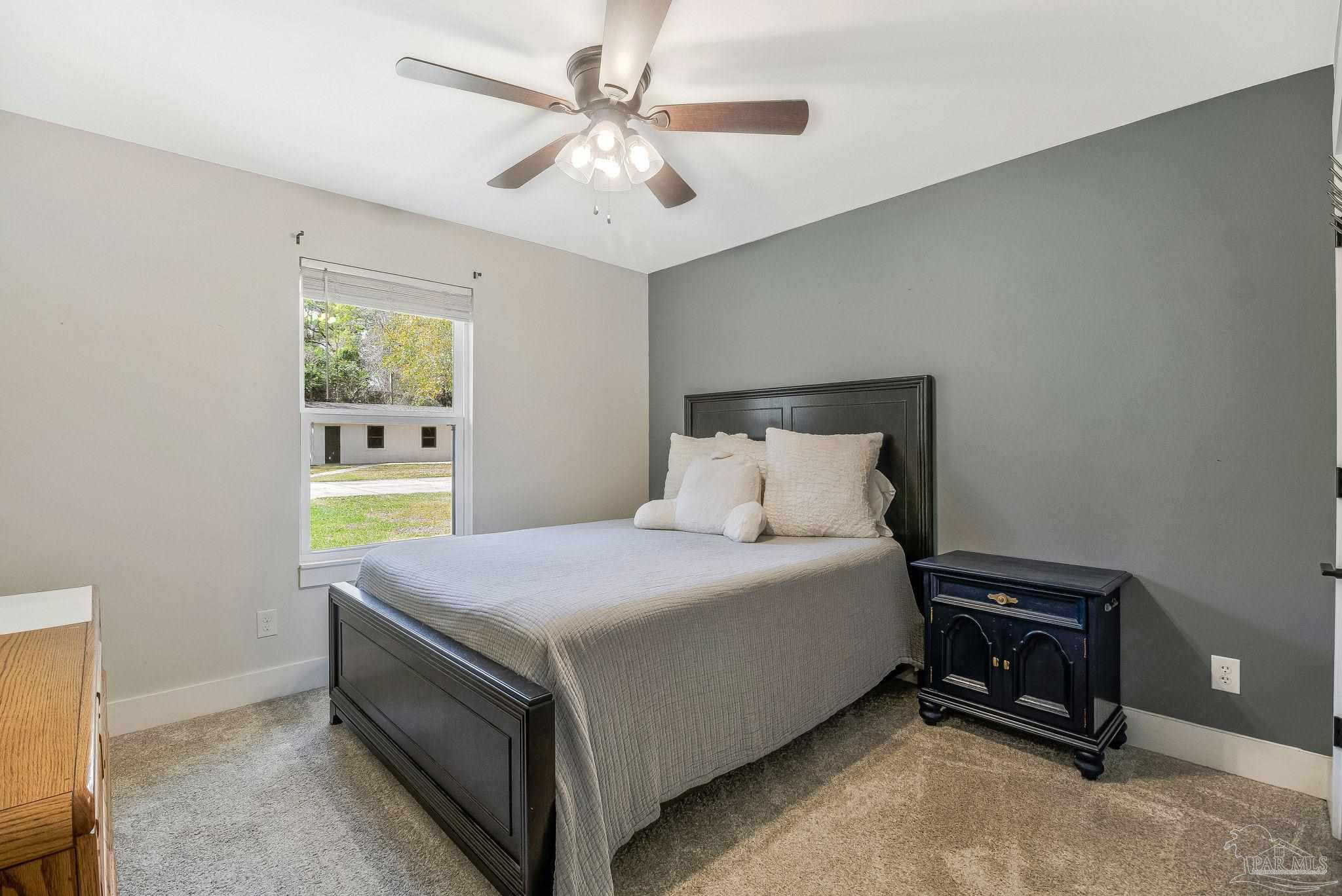 7175 Wallace Drive Pace, FL 32571 - Photo 47 of 71 a bedroom with a bed and a chandelier