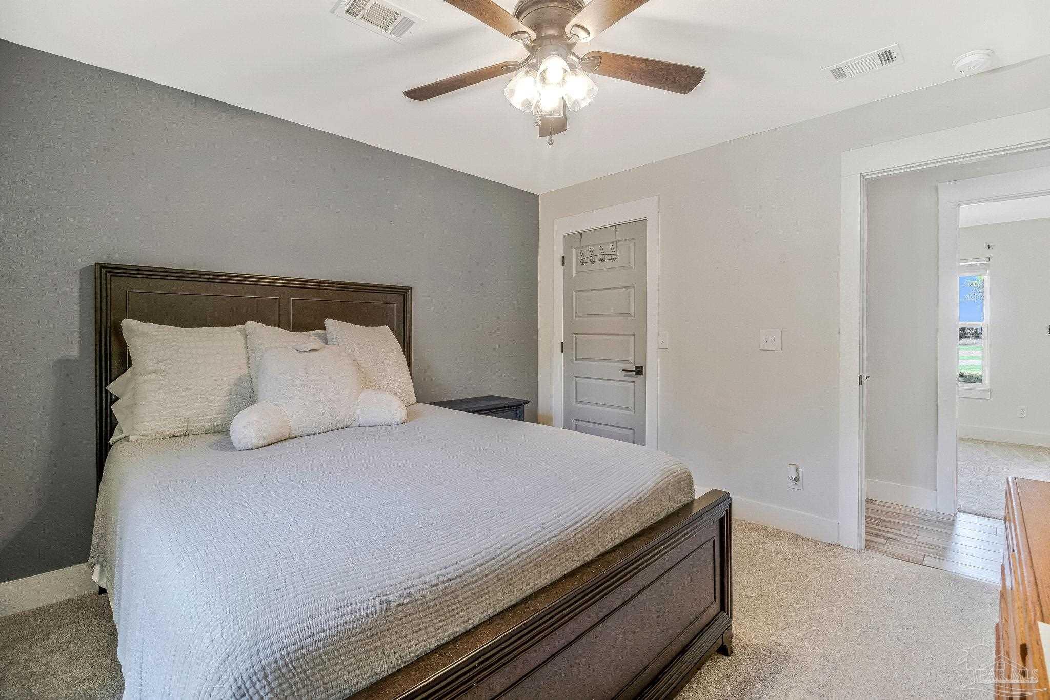 7175 Wallace Drive Pace, FL 32571 - Photo 48 of 71 a bedroom with a bed and a chandelier
