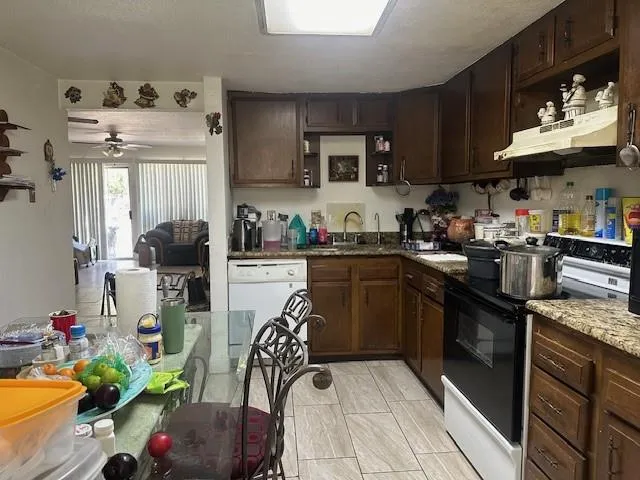 a kitchen with stainless steel appliances granite countertop a sink dishwasher stove top oven and cabinets with wooden floor