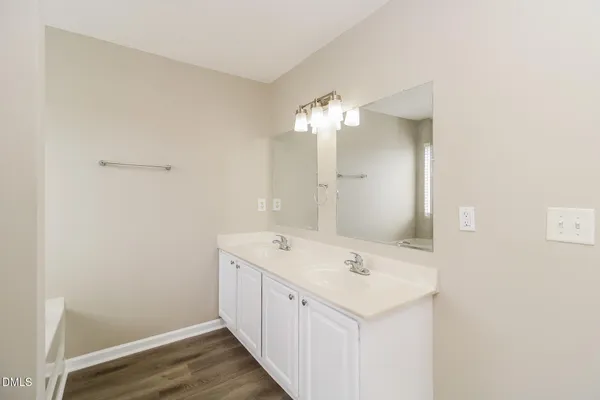an empty room with wooden floor chandelier fan and windows