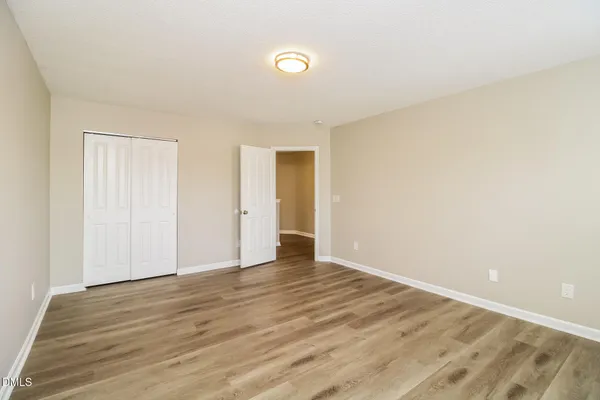 a view of an empty room with wooden floor