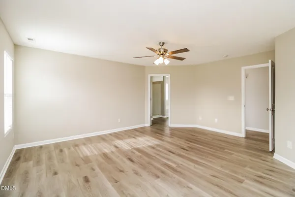 a view of an empty room with wooden floor