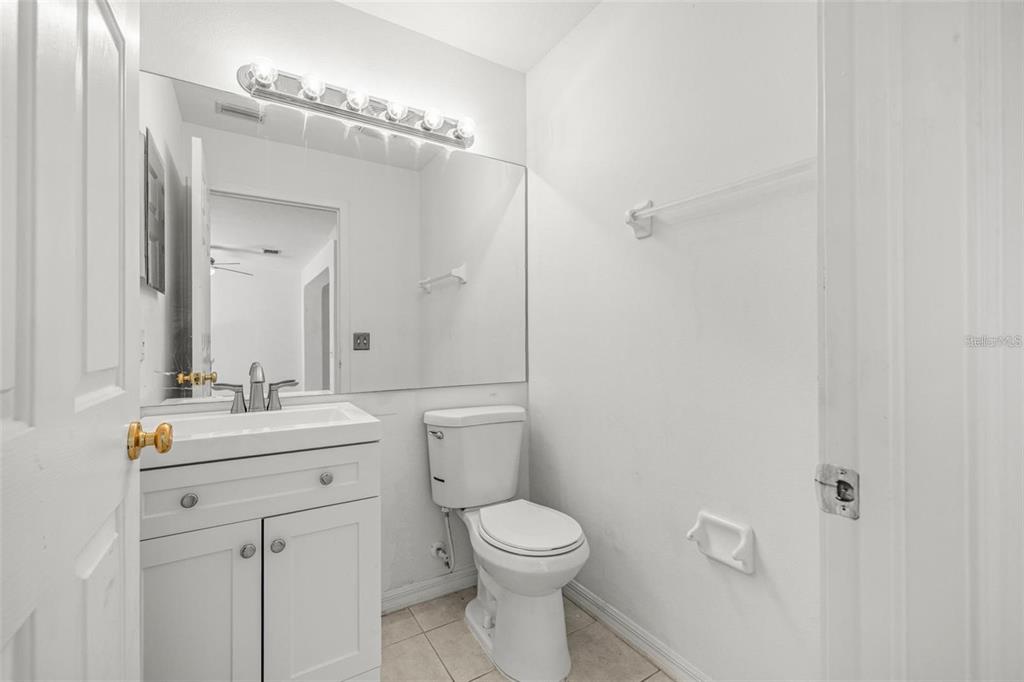 8010 Thoroughbred Loop Largo, FL 33773 - Photo 12 of 29 a bathroom with a toilet a sink a mirror and vanity