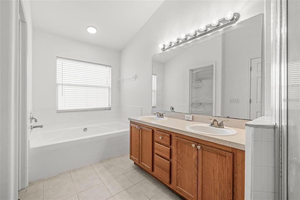 8010 Thoroughbred Loop Largo, FL 33773 - Photo 20 of 29 a spacious bathroom with a double vanity sink mirror double and bathtub
