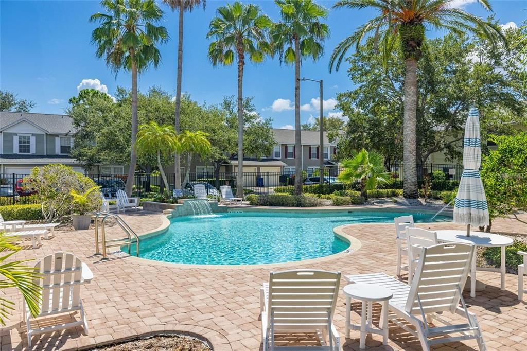 8010 Thoroughbred Loop Largo, FL 33773 - Photo 29 of 29 a view of a patio with table and chairs potted plants and palm trees