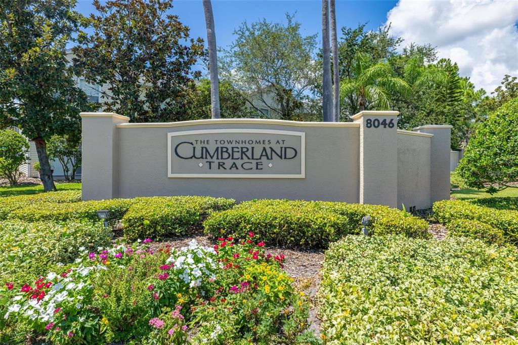 8010 Thoroughbred Loop Largo, FL 33773 - Photo 3 of 29 a sign broad in front of flowers