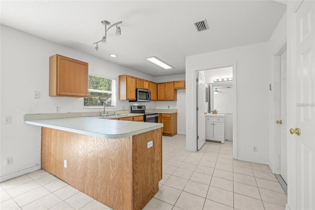 8010 Thoroughbred Loop Largo, FL 33773 - Photo 8 of 29 a kitchen with stainless steel appliances granite countertop a sink and a refrigerator