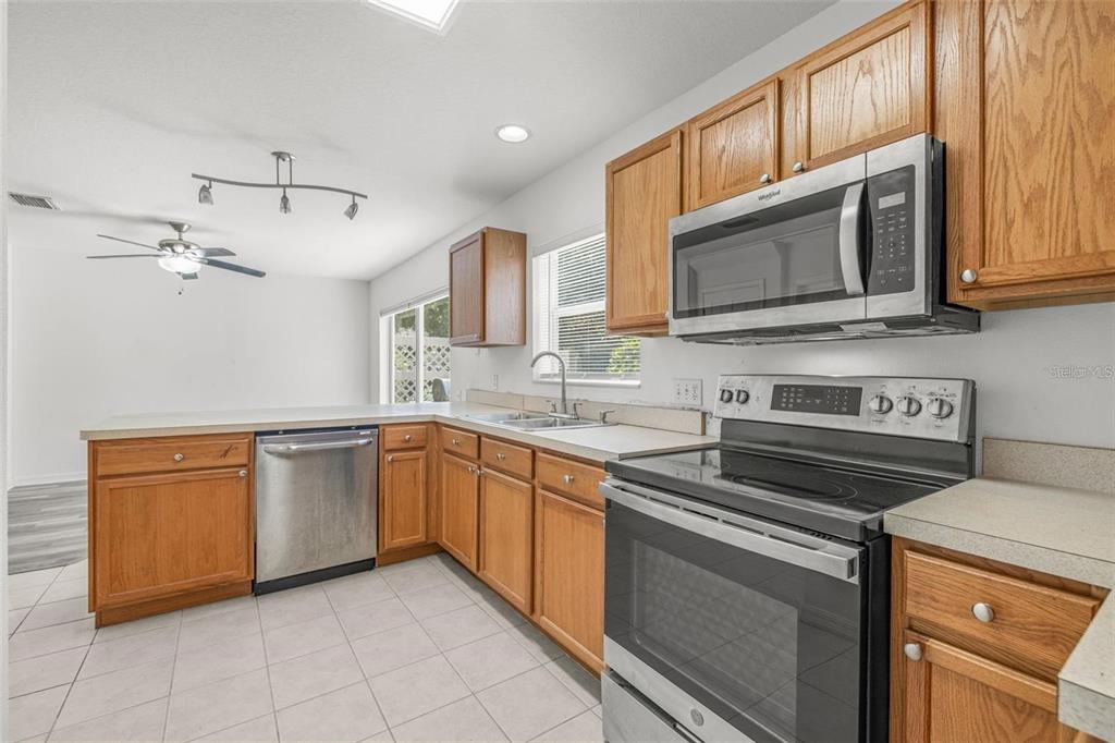 8010 Thoroughbred Loop Largo, FL 33773 - Photo 10 of 29 a kitchen with stainless steel appliances granite countertop a stove microwave and sink