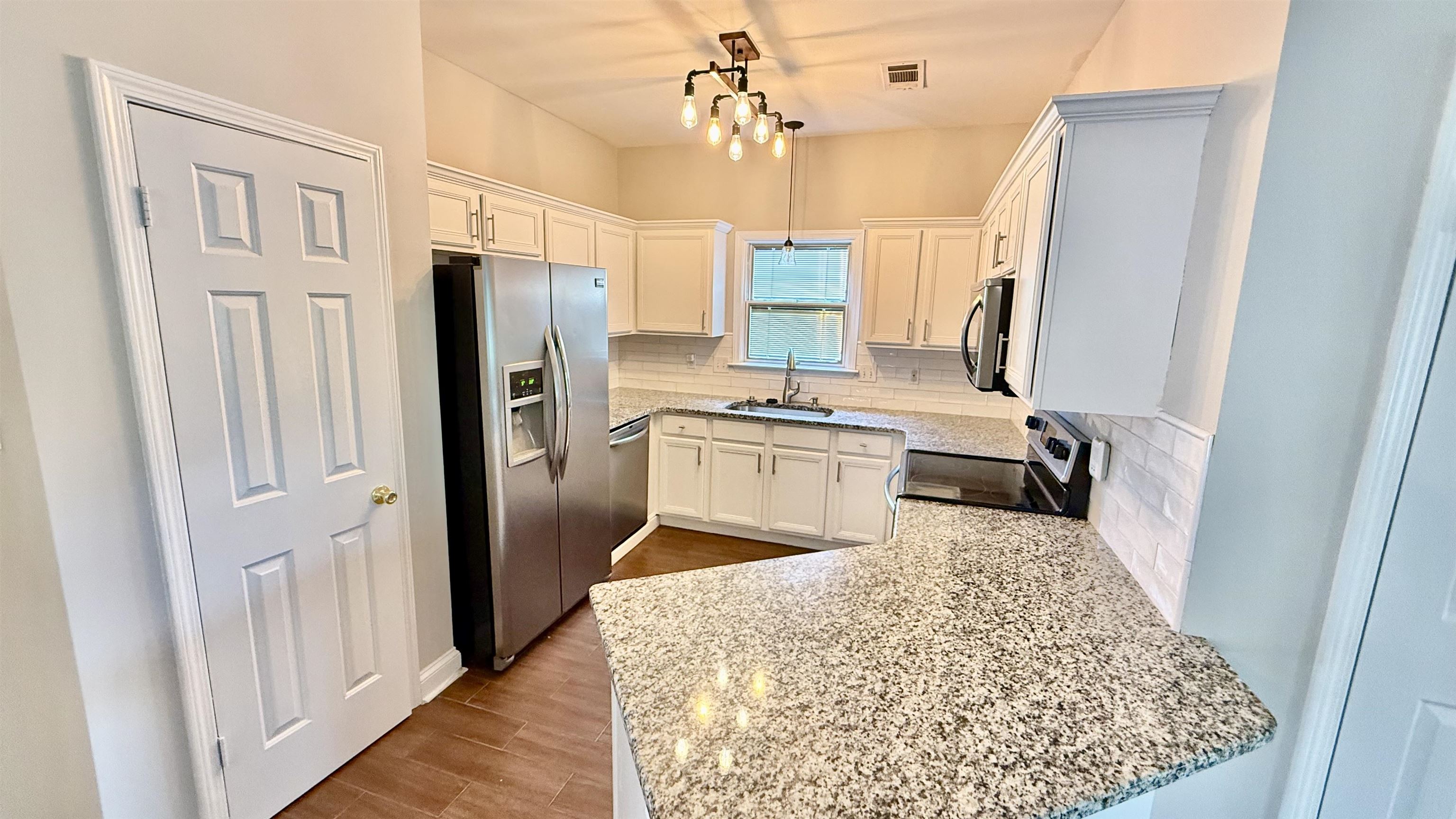 184 Marrakesh Circle Memphis, TN 38103 - Photo 9 of 34 a kitchen with stainless steel appliances granite countertop a refrigerator a stove and white cabinets