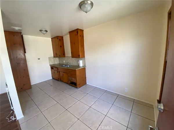 an empty room with wooden floor and cabinets