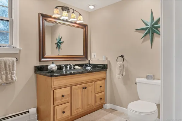 a bathroom with a toilet a sink a vanity and mirror