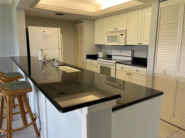 a kitchen with kitchen island a sink stove and cabinets