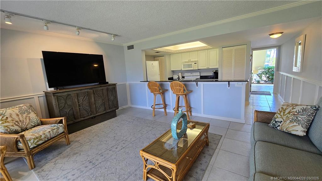 5565 Northeast Gulfstream Way Stuart, FL 34996 - Photo 14 of 21 a living room with furniture and a flat screen tv