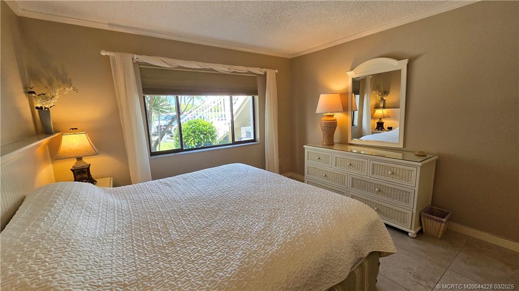 5565 Northeast Gulfstream Way Stuart, FL 34996 - Photo 15 of 21 a bedroom with a bed and a window