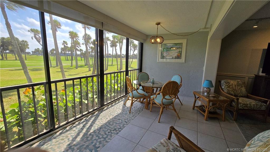 5565 Northeast Gulfstream Way Stuart, FL 34996 - Photo 8 of 21 a dining room with furniture a chandelier and wooden floor