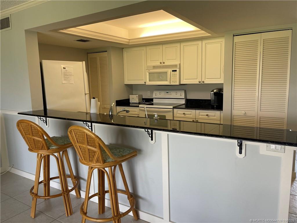 5565 Northeast Gulfstream Way Stuart, FL 34996 - Photo 10 of 21 a kitchen with stainless steel appliances granite countertop a stove a sink and a refrigerator