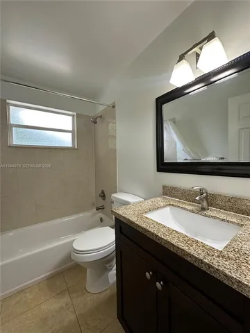 a bathroom with a granite countertop sink a toilet and a bathtub