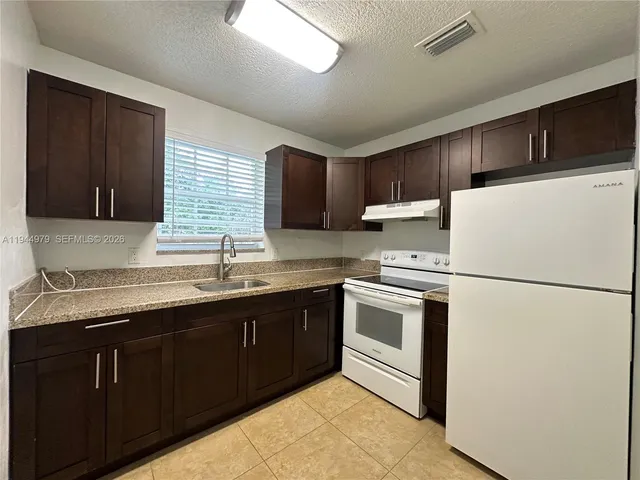a kitchen with a sink a stove and refrigerator