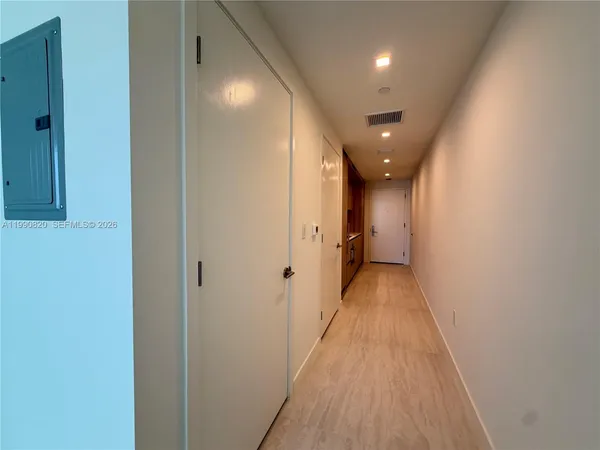 a view of a hallway with wooden floor