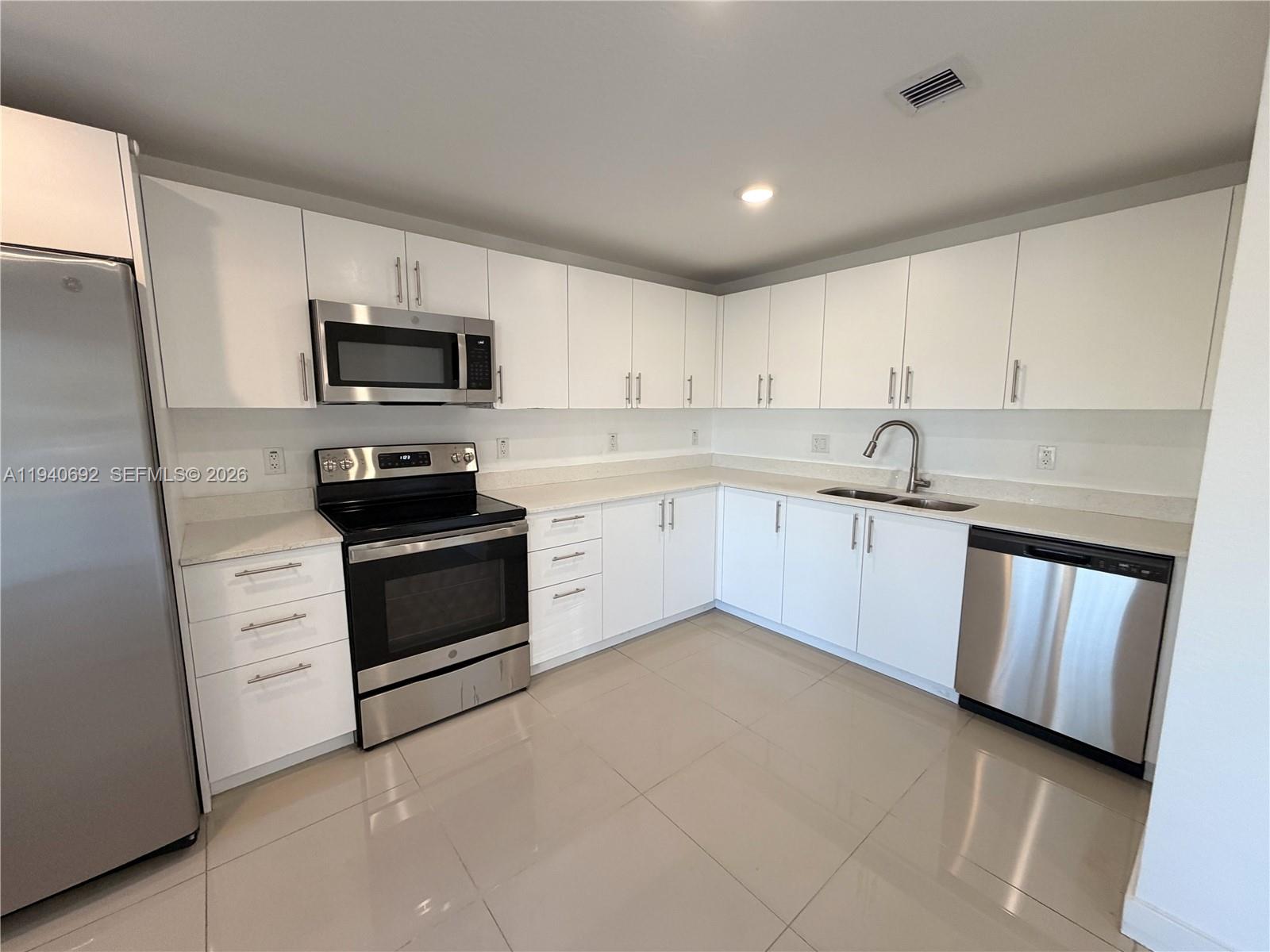 25823 Southwest 145th Avenue Miami, FL 33170 - Photo 5 of 18 a kitchen with white cabinets stainless steel appliances and sink