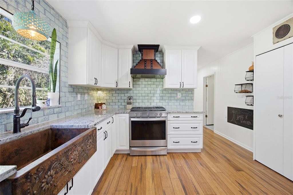 10550 Northeast 222nd Place Road Fort McCoy, FL 32134 - Photo 16 of 48 a kitchen with stainless steel appliances granite countertop a stove and a sink