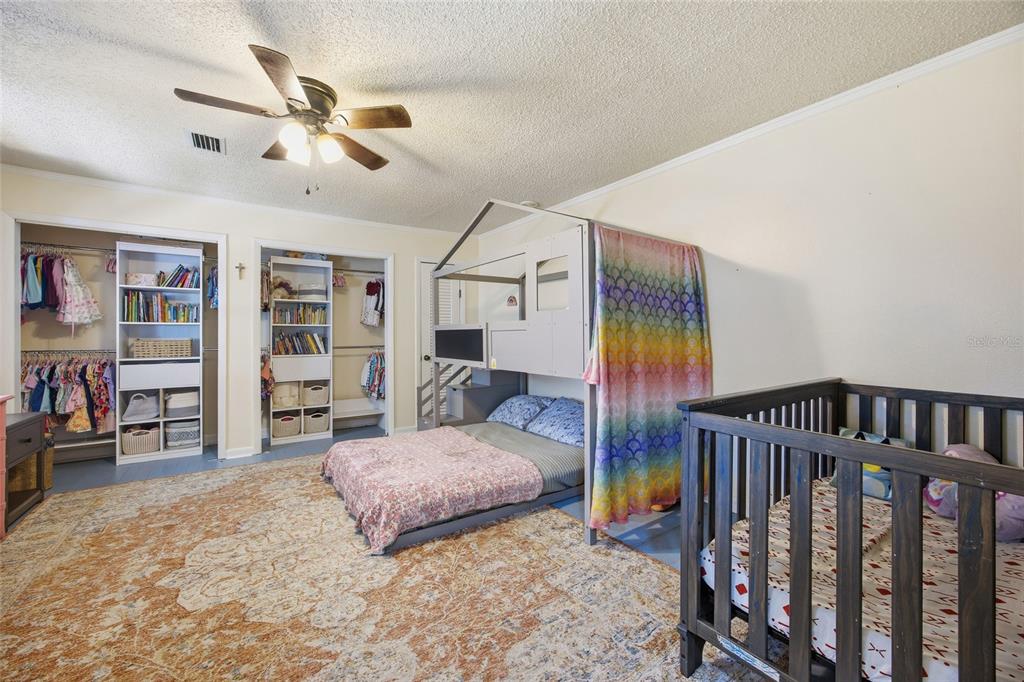 10550 Northeast 222nd Place Road Fort McCoy, FL 32134 - Photo 23 of 48 a bedroom with furniture and a chandelier