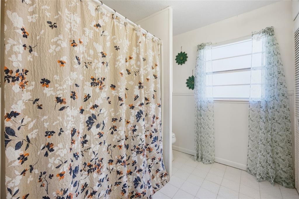 10550 Northeast 222nd Place Road Fort McCoy, FL 32134 - Photo 26 of 48 a bathroom with a shower curtain