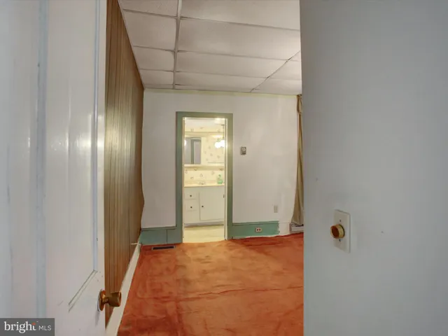 a view of a room with a chandelier fan and windows
