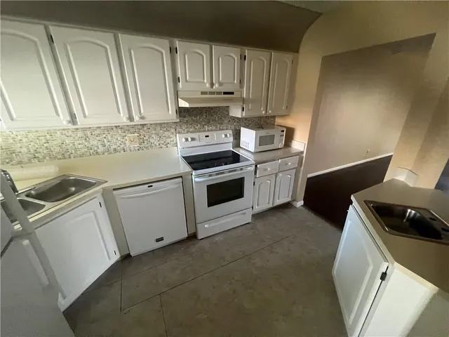 a kitchen with a sink and a stove top oven