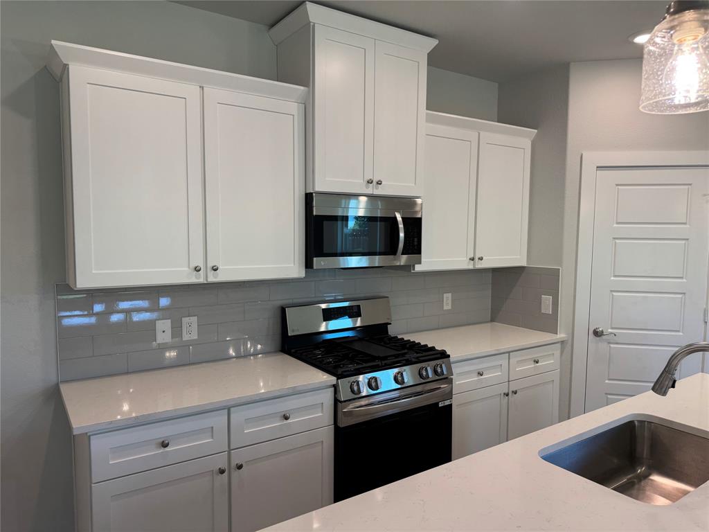 612 Finlee Way Tioga, TX 76271 - Photo 13 of 23 a kitchen with white cabinets sink and stainless steel appliances