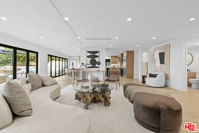 a dining hall with stainless steel appliances a dining table and chairs with kitchen view