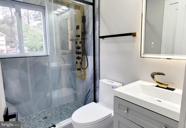 a bathroom with a sink a toilet and shower