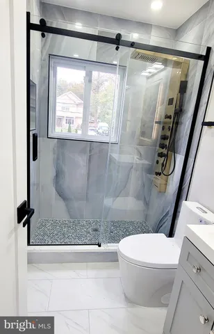 a white toilet sitting next to a bath tub shower