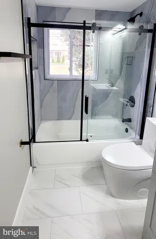 a bathroom with a toilet and a shower