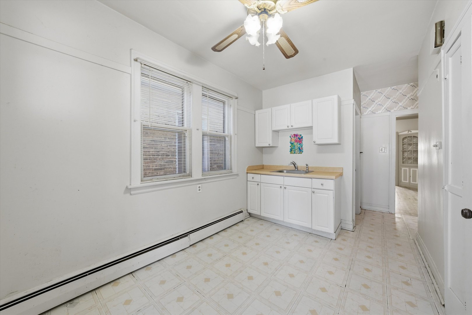 3822 West 64th Street Chicago, IL 60629 - Photo 12 of 33 a kitchen with a refrigerator and white cabinets