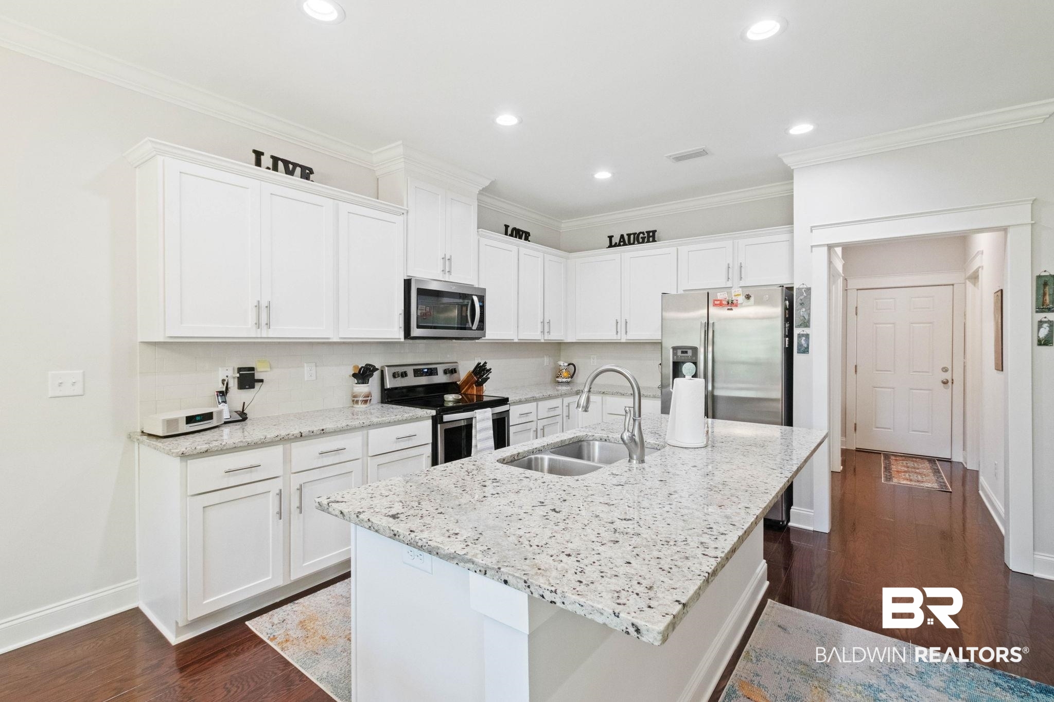 192 Mark Twain Loop Foley, AL 36535 - Photo 17 of 42 Kitchen featuring dark hardwood / wood-style flooring, white cabinets, sink, a center island with sink, and appliances with stainless steel finishes