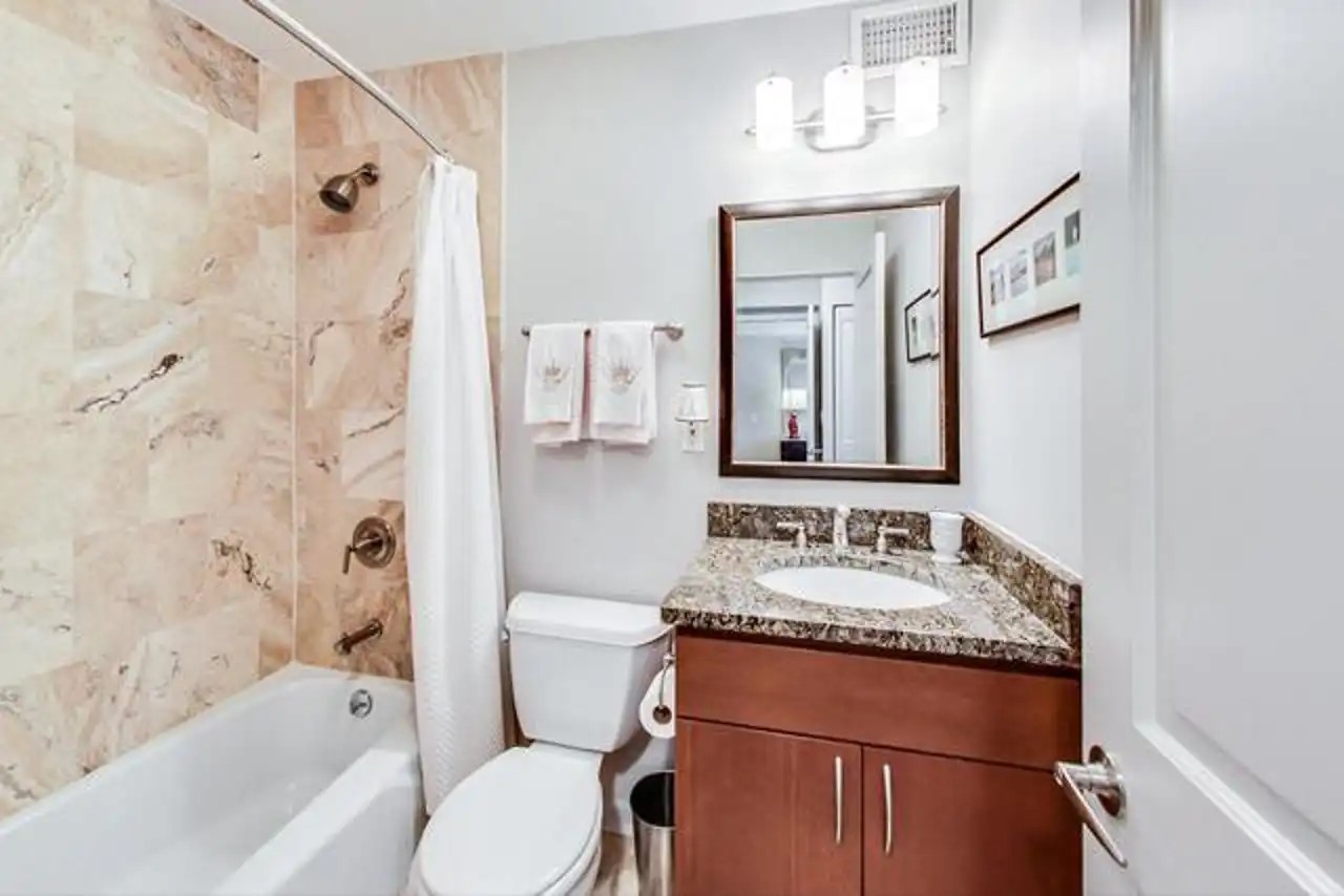1430 North Astor Street, Unit 19C Chicago, IL 60610 - Photo 23 of 41 a bathroom with a granite countertop tub sink and mirror