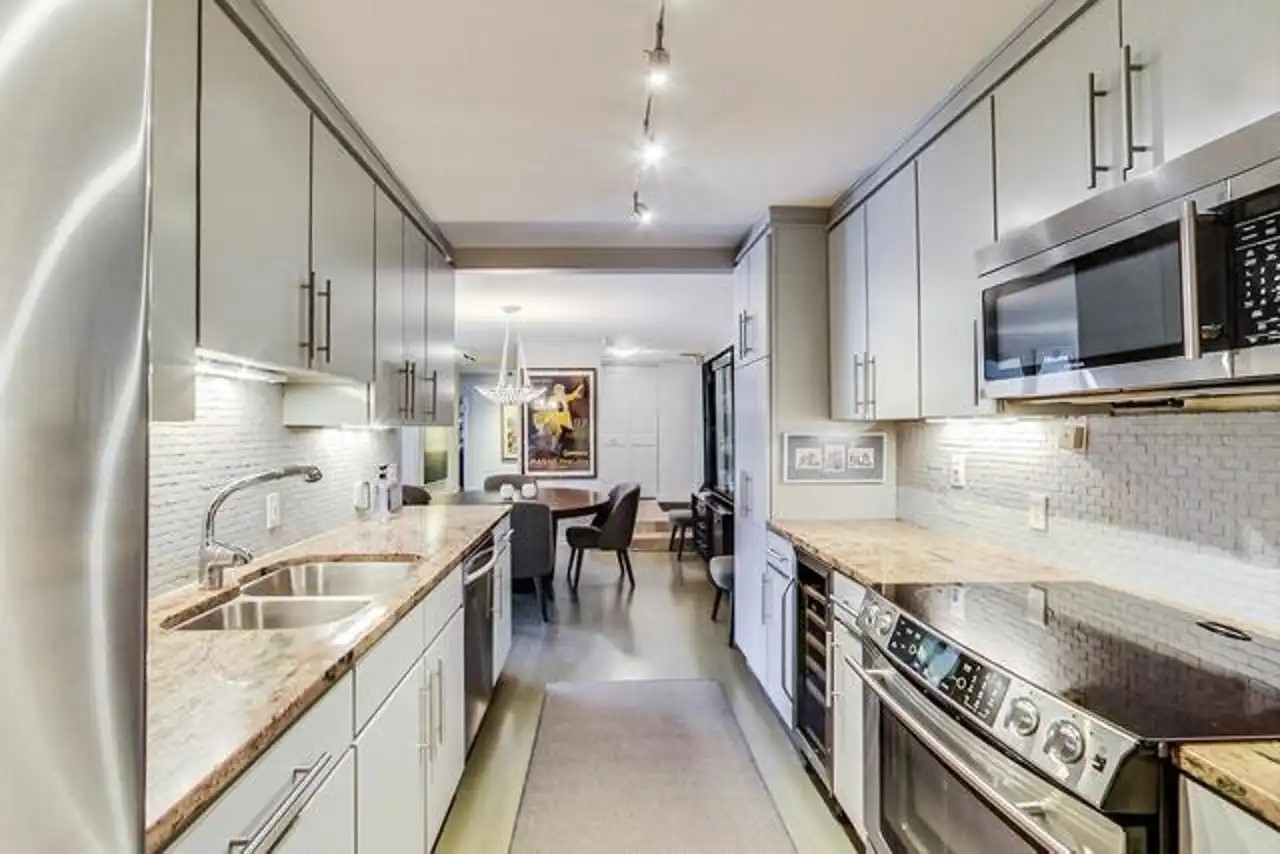 1430 North Astor Street, Unit 19C Chicago, IL 60610 - Photo 10 of 41 a large kitchen with stainless steel appliances granite countertop a lot of counter space and wooden floors