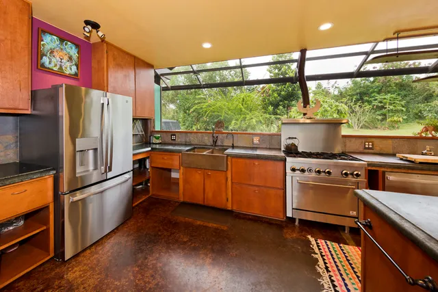 a kitchen with stainless steel appliances granite countertop a refrigerator a sink and a stove