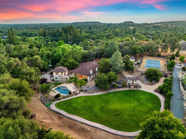 a kitchen with granite countertop a stove a sink a dining table and chairs