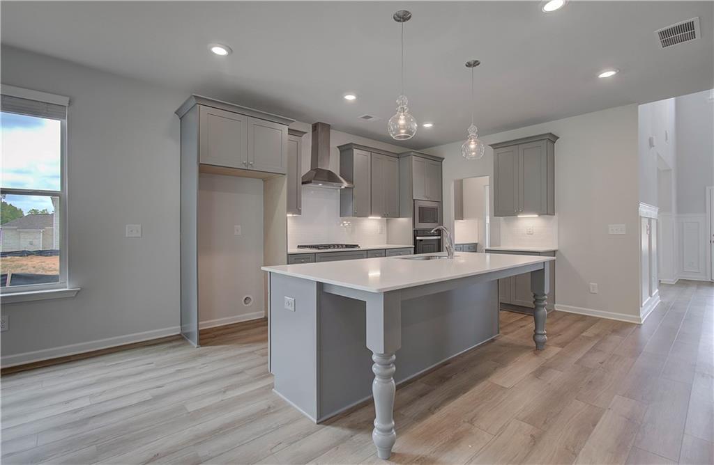 116 Haverling Pass Hampton, GA 30228 - Photo 14 of 38 a kitchen with stainless steel appliances granite countertop a sink a stove a refrigerator and a oven with wooden floor