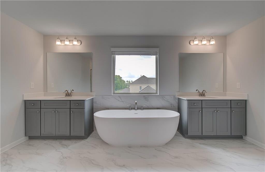 116 Haverling Pass Hampton, GA 30228 - Photo 33 of 38 a spacious bathroom with a double vanity sink a mirror and a bathtub