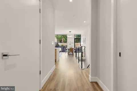 a kitchen with stainless steel appliances a white stove top oven a sink dishwasher and a refrigerator with wooden floor