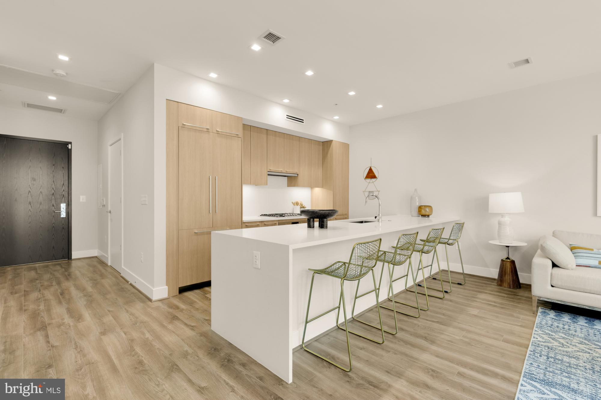 1628 11th Street Northwest, Unit 105 Washington, DC 20001 - Photo 6 of 55 a kitchen with stainless steel appliances a white stove top oven a sink dishwasher and a refrigerator with wooden floor