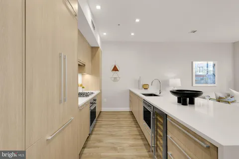 a kitchen with a stove and a wooden floor