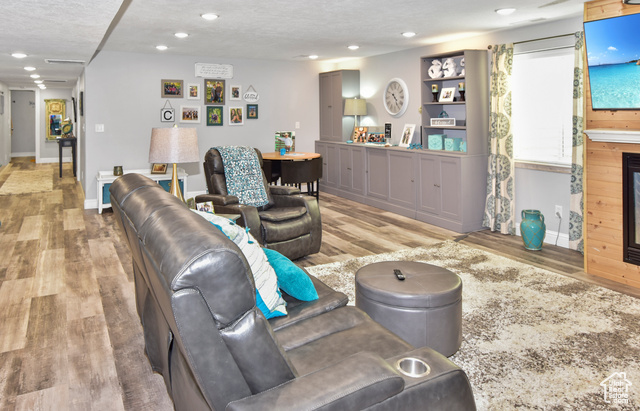 1500 Fish Creek Road Bancroft, ID 83217 - Photo 22 of 45 Living room with light wood-type flooring, a textured ceiling, recessed lighting, and a fireplace
